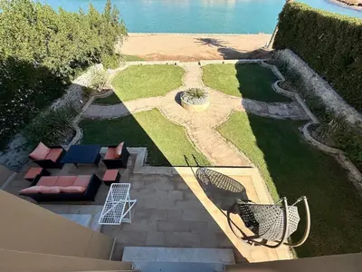 an aerial view of a garden with chairs and the water at Picturesque 3BR Villa- Free Lagoon Access ElGouna in Hurghada
