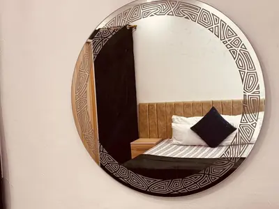 a mirror on a wall with a bed in a room at Prestige Home apartment in Hurghada
