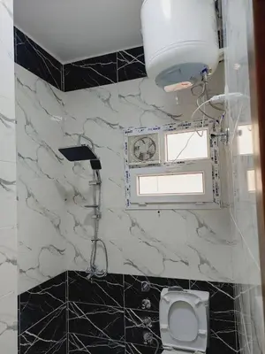 a bathroom with a white toilet and a marble wall at Wohnung in Al Ahyaa Hurghada in Hurghada