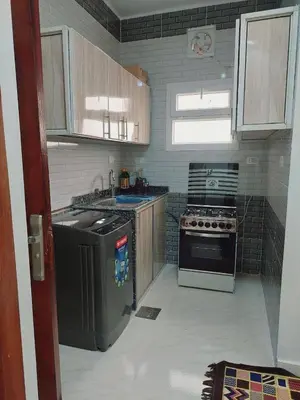 a small kitchen with a stove and a refrigerator at Wohnung in Al Ahyaa Hurghada in Hurghada