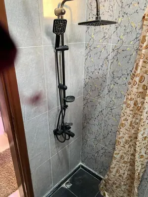 a shower in a bathroom with a shower head at Family House in Luxor