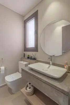 a bathroom with a sink and a toilet and a mirror at Stylish 3 BR Retreat at Ancient Hills El Gouna in El Gouna