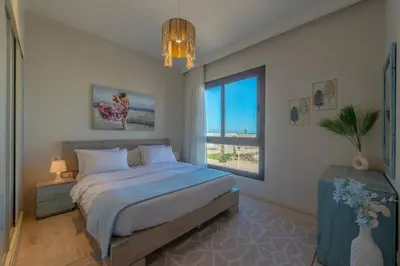 a bedroom with a large bed and a large window at Stylish 3 BR Retreat at Ancient Hills El Gouna in El Gouna
