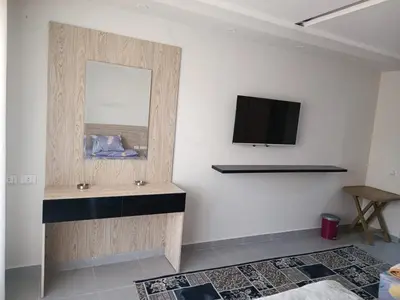 a room with a mirror and a tv on a wall at Sunset View at scandic Beach WIFI in Hurghada