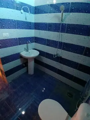 a blue and white bathroom with a sink and a toilet at Mashamman nuban house in Aswan