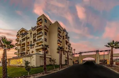 a large building with palm trees in front of it at Hurghada Escape Pool and Sea View in Hurghada