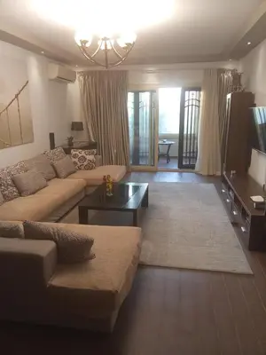 a living room with a couch and a tv at , كمبواند قمريه in Hurghada