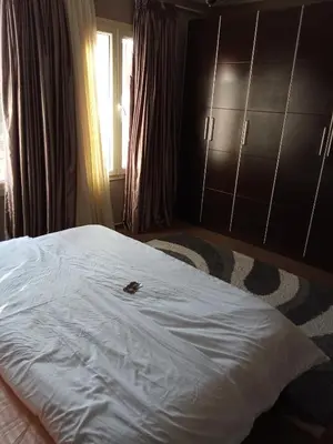 a bedroom with a large white bed and a window at , كمبواند قمريه in Hurghada