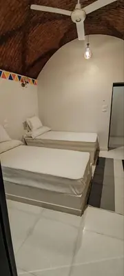 two beds in a room with a ceiling at Kemet Guest House in Aswan
