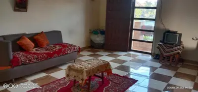 a living room with a couch and a tv at Al Agamay Nile view guest House in Jazīrat Aswān