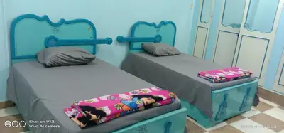 a room with two twin beds in a room at Al Agamay Nile view guest House in Jazīrat Aswān