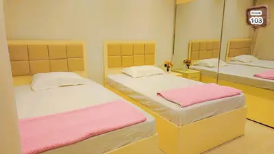 a bedroom with two beds with mirrors and pink sheets at Relaxing apartment in Hurghada