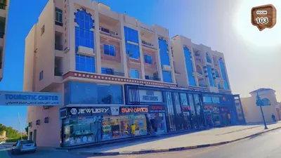 a large building on a street corner with a store at Relaxing apartment in Hurghada