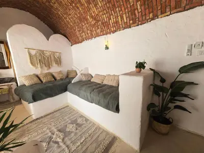 a room with two beds and a couch in it at Nala Narty Nubian House & Organic Farm in Aswan