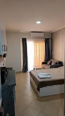 a bedroom with a bed and a couch in it at Cozy studio Florenza Khamsin in Hurghada