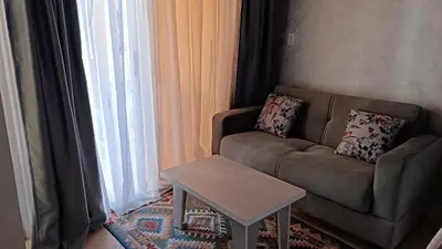 a living room with a couch and a table at Cozy studio Florenza Khamsin in Hurghada