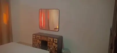 a mirror hanging on a wall next to a bed at Good place to enjoy vacation in Hurghada