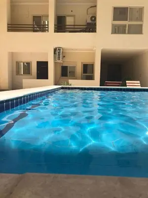 a large blue swimming pool in front of a building at Good place to enjoy vacation in Hurghada