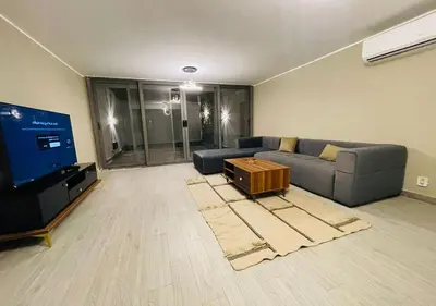 a living room with a couch and a flat screen tv at Comfort 3BR Apartment C1-D with Private Heated Pool at Bali Elgouna in Hurghada