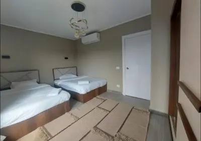 a bedroom with two beds and a chandelier at Comfort 3BR Apartment C1-D with Private Heated Pool at Bali Elgouna in Hurghada