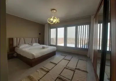 a bedroom with a bed and a chandelier at Comfort 3BR Apartment C1-D with Private Heated Pool at Bali Elgouna in Hurghada