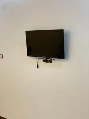 a flat screen tv hanging on a white wall at King TuT house in Luxor