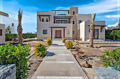 a large white house with palm trees and a pathway at inchant sands elgouna luxury villa in Hurghada