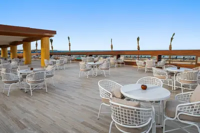 a patio with tables and chairs on a deck at Albatros Makadi Resort - 24 HRS All Inclusive in Hurghada