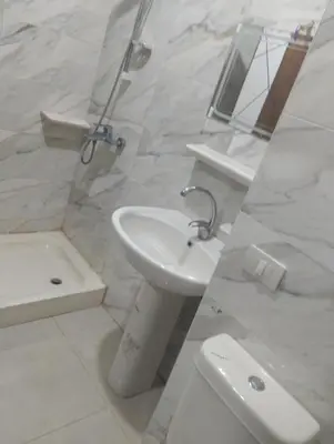 a white bathroom with a sink and a toilet at Golden Tayeb Hurghada Compound in Hurghada