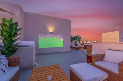 a living room with a tv and a couch at Coastal Vibe 2BR Mangroovy Gouna with Rooftop Cinema, BBQ, Pool & Beach Access in Hurghada
