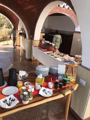 a table with plates of food and people in a kitchen at Kaya Nubian House in Aswan