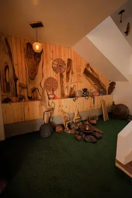 a room with wooden walls and green carpet at Kaya Nubian House in Aswan