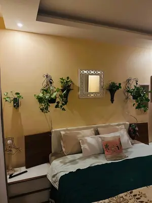 a bedroom with a bed with plants on the wall at شاليه في ستيلا مكادي الغردقة in Hurghada