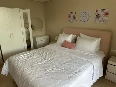 a bedroom with a white bed and a mirror at Pool & Sea View 2BR in Mangroovy in Hurghada