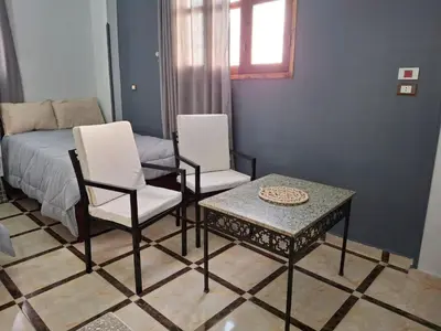 a room with two chairs and a table and a bed at Ezba Guest House in Luxor