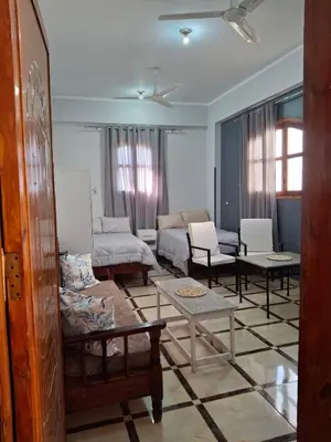 a living room with couches and tables in it at Ezba Guest House in Luxor