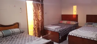 a bedroom with two beds and a window at Nile palace in Jazīrat Aswān