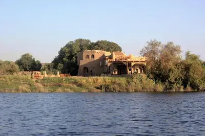 a house on the shore of a body of water at Shalal Farm and guest house in Aswan