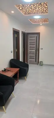 a living room with two black chairs and a table at Gannet Alyousef City Center in Naj‘ al Maḩaţţah
