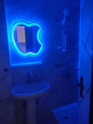 a blue lighted bathroom with a sink and a mirror at Tiba Golden a in Hurghada