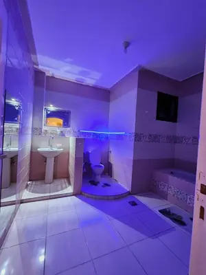 a bathroom with purple lighting and a toilet and sink at Nopian 1 in Luxor