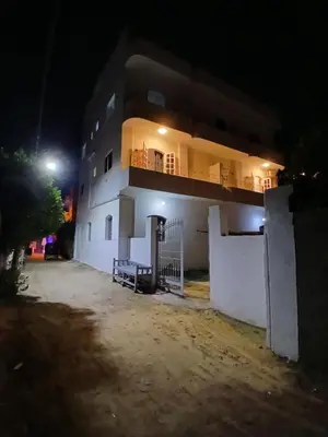 a white building with a balcony at night at Nopian 1 in Luxor