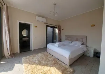 a bedroom with a large white bed and a rug at Private 2BR Apartment with Private Heated Pool at Bali D3 in Hurghada
