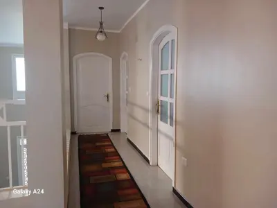 a hallway with two white doors and a tile floor at Valencia Villa & Rooms in Luxor