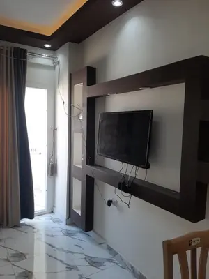 a living room with a flat screen tv on a wall at شقه سوبر لوكس in Hurghada