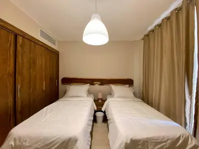 two beds in a small room with a lamp at 2BR Mangroovy Ground floor in Hurghada