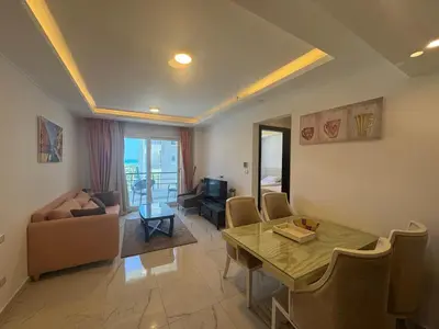 a living room with a table and a couch at Cozy one bedroom in a compound with beach ac in Hurghada