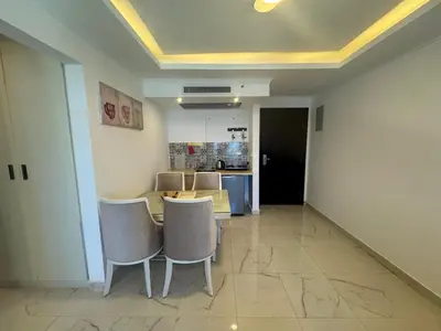 a room with a table and chairs and a kitchen at Cozy one bedroom in a compound with beach ac in Hurghada