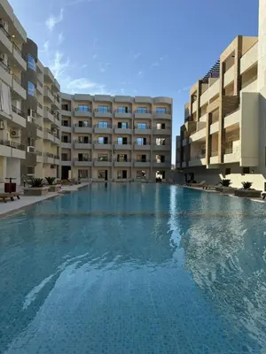 a large swimming pool in front of a building at Cozy Studio 1st Avenue South Side in Hurghada