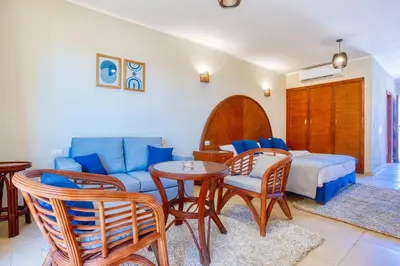 a living room with a couch and a bed and a table at Cozy Studio 1st Avenue South Side in Hurghada